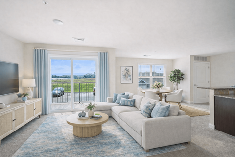 A living room with a white couch and a television.