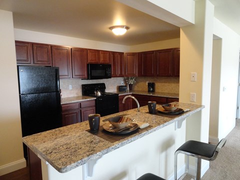 a kitchen with black appliances and granite counter tops