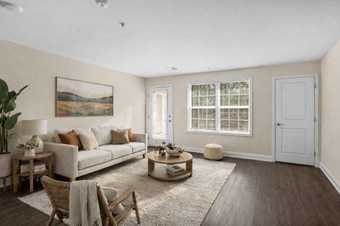 A living room with a couch, chairs, and a painting on the wall.
