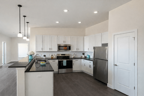 A modern kitchen with white cabinets and stainless steel appliances.