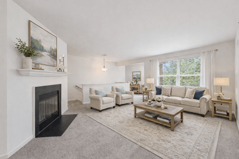 A living room with a fireplace and a painting on the wall.