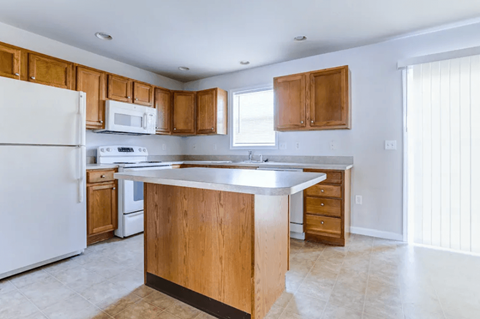 A kitchen with wooden cabinets and a white refrigerator.