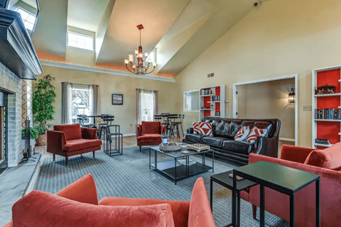 A living room with red chairs and a black couch.