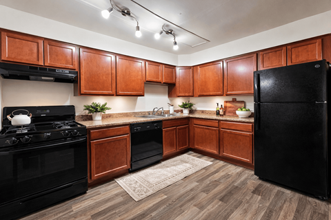 A kitchen with wooden cabinets and black appliances.