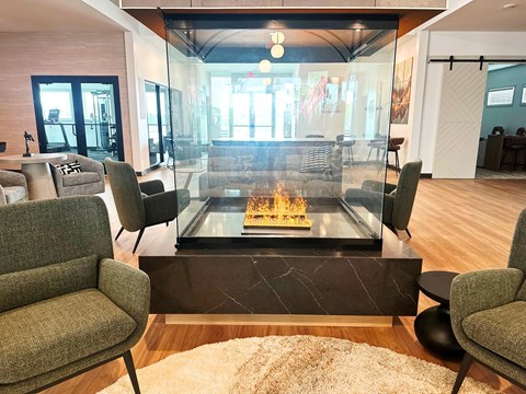 A modern living room with a glass table and grey chairs.