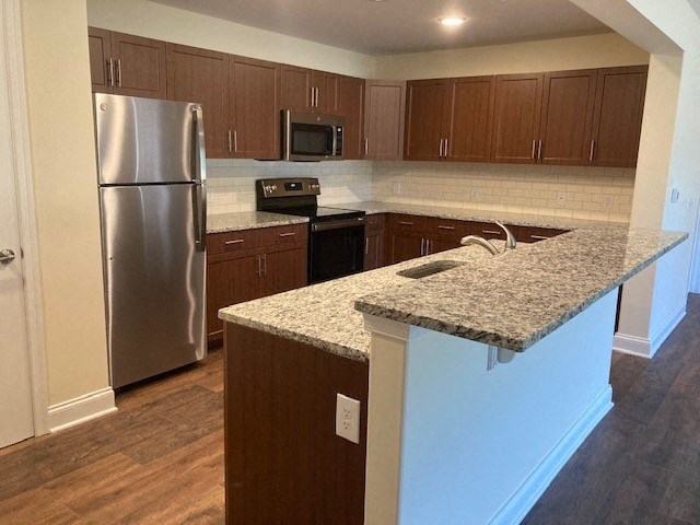a kitchen with a granite counter top and a stainless steel refrigerator