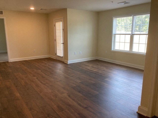an empty living room with a hard wood floor