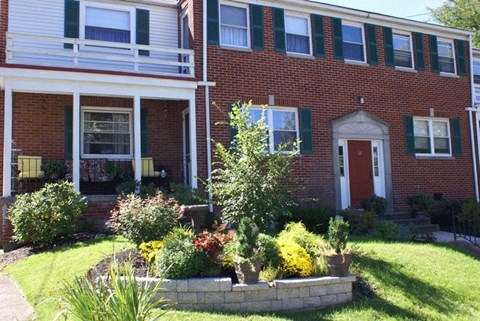 a red brick house with a garden in front of it