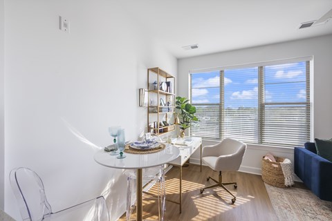 A dining room with a white table and chairs.