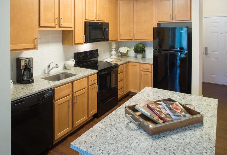 A kitchen with wooden cabinets and black appliances.