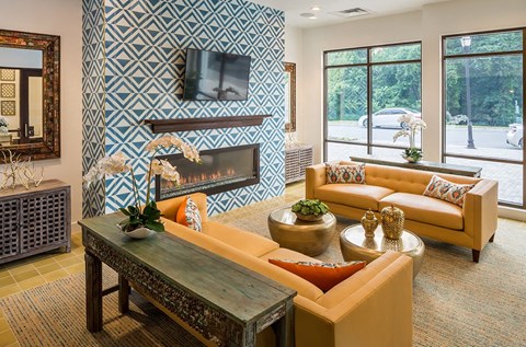A living room with a fireplace and a television on the wall.