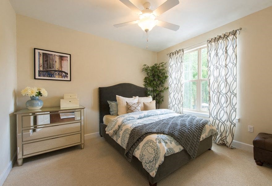 A bedroom with a large bed and a ceiling fan.