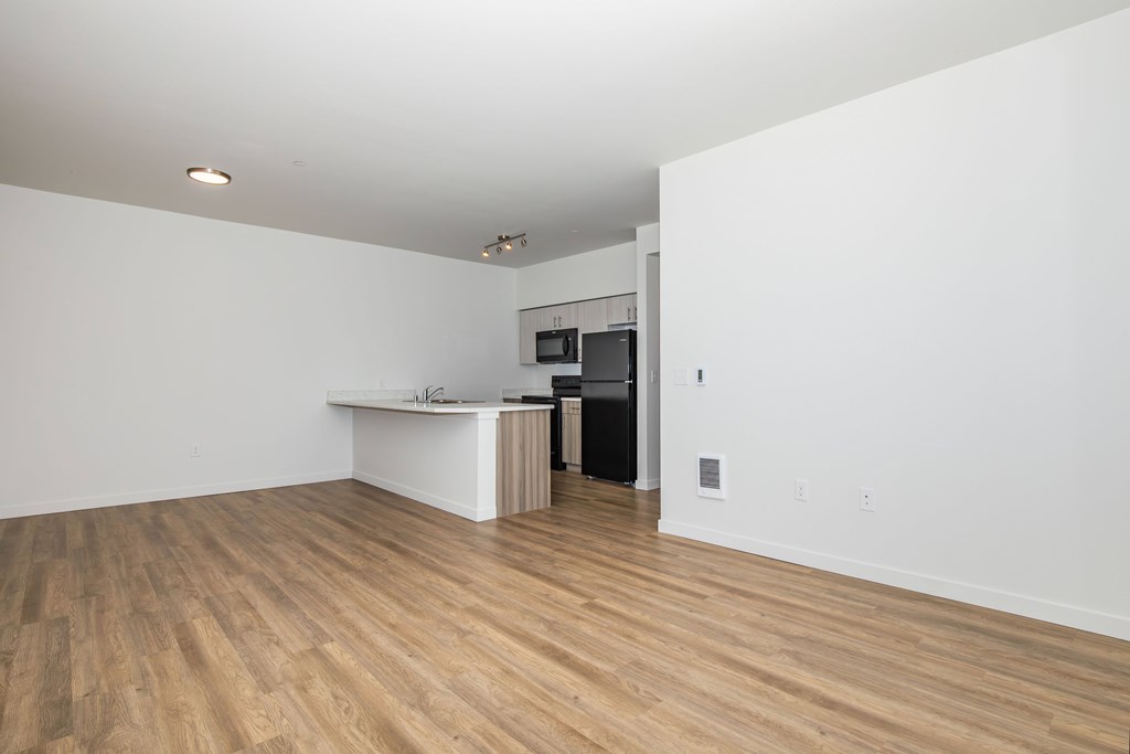 A room with a white counter and a black refrigerator.