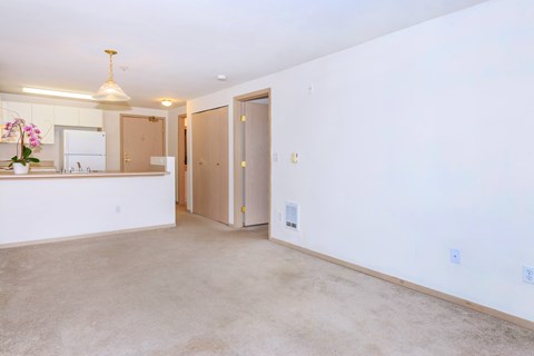 A kitchen with a sink, a refrigerator, and a counter with a vase of flowers on it.