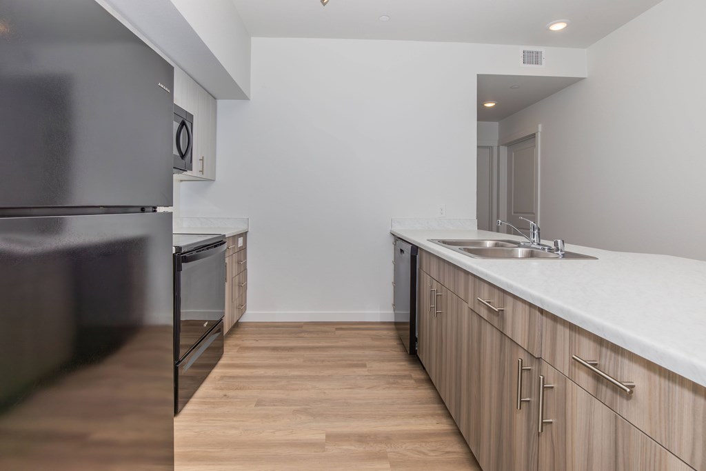 A kitchen with wooden floors and white countertops.