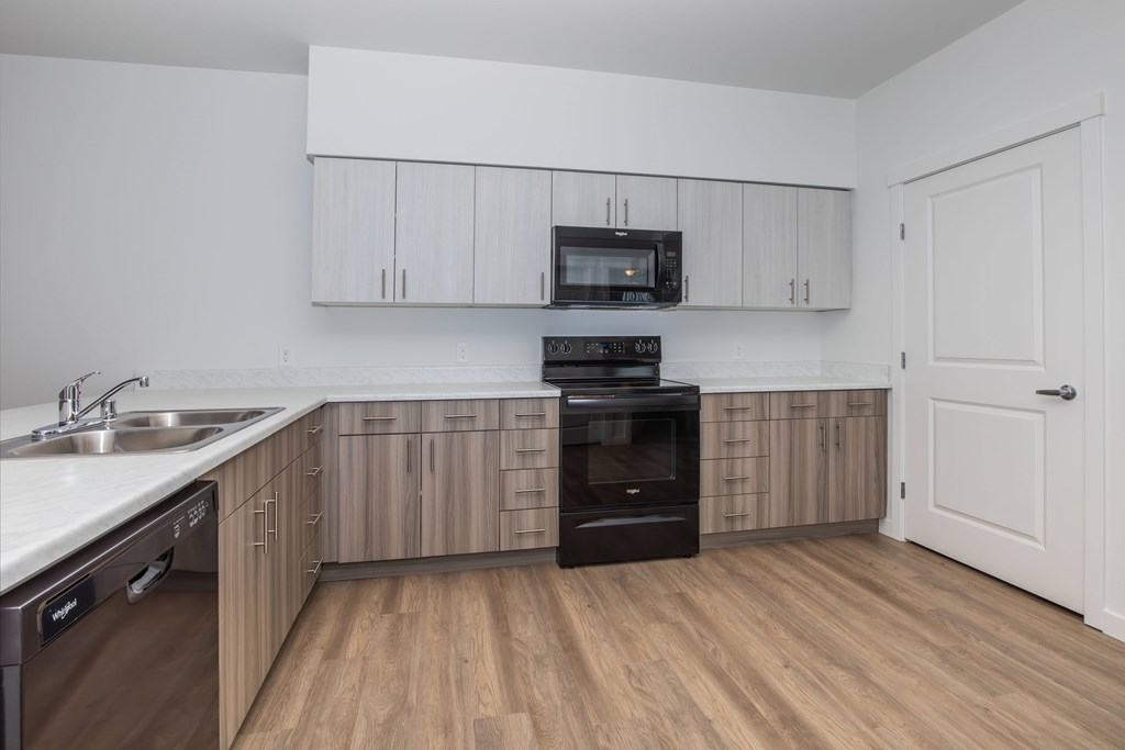 A kitchen with wooden floors and white walls.