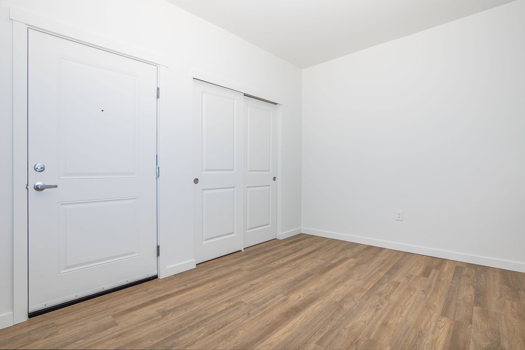 A room with two doors and wooden flooring.