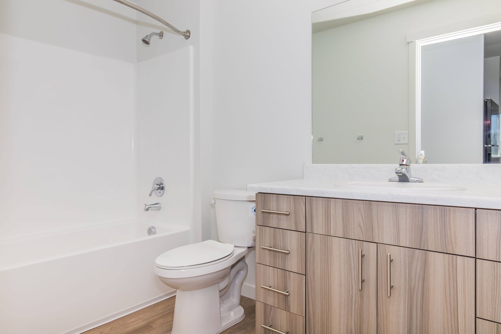 A white toilet in a bathroom with wooden cabinets.