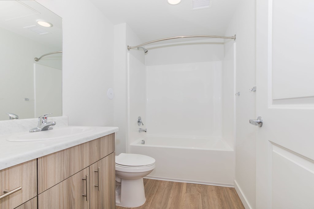 A white bathroom with a toilet, sink, and bathtub.