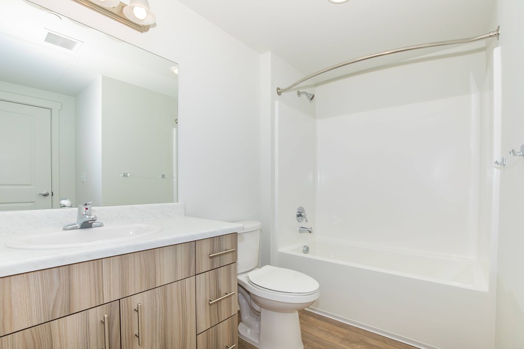 A white bathroom with a sink, toilet, and bathtub.