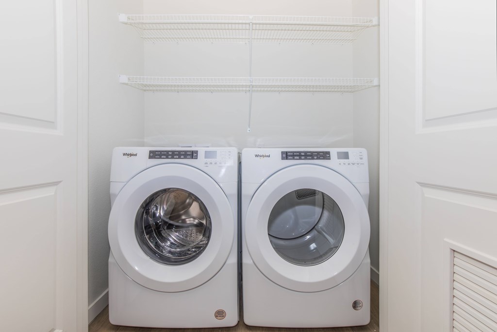 Two front loading washing machines in a small laundry room.