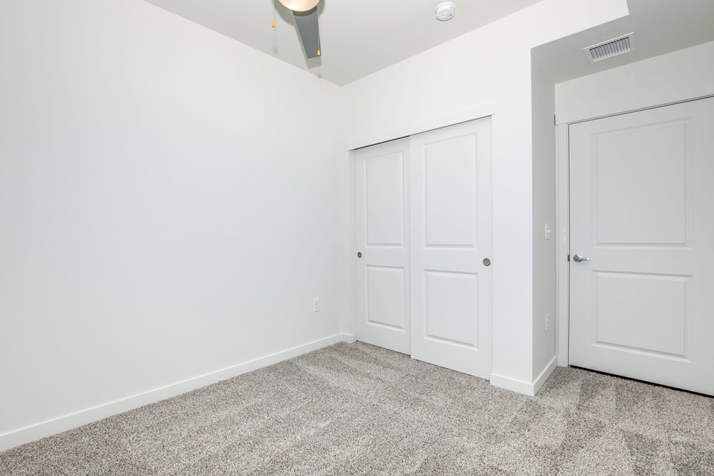 A room with two doors and a ceiling fan.