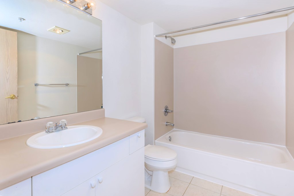 A white bathroom with a sink, toilet, and bathtub.