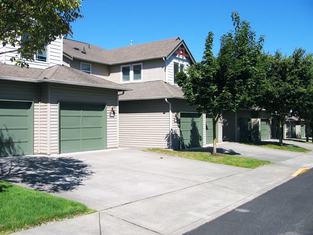 A row of houses with green garage doors.