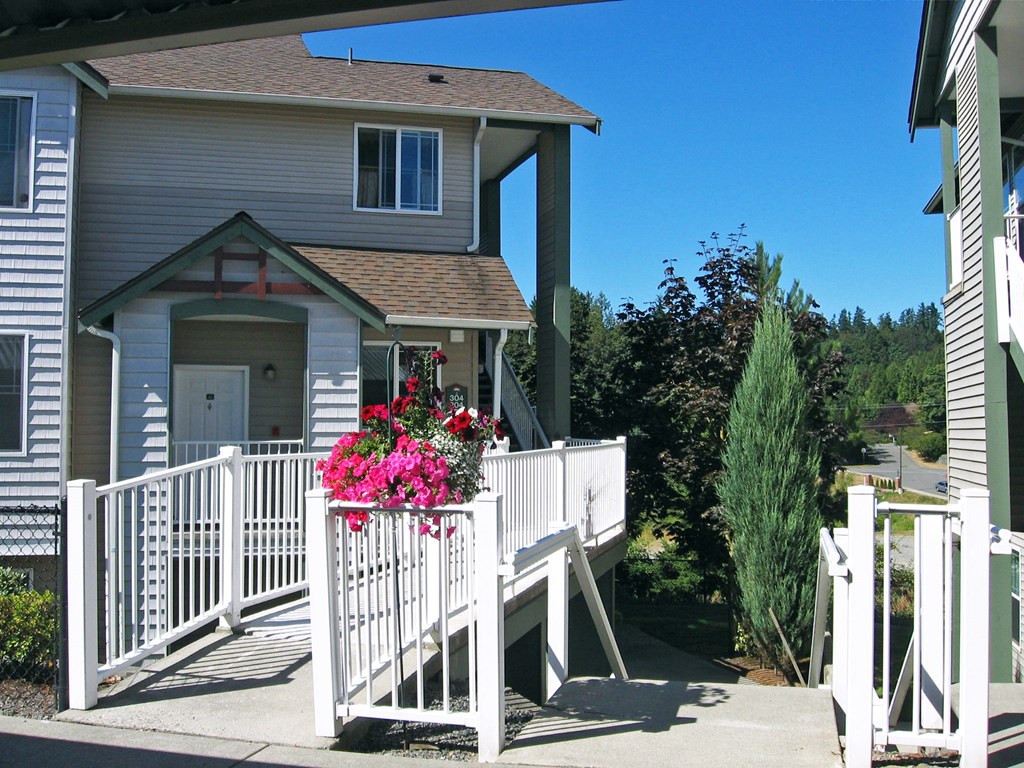A house with a white fence and pink flowers.