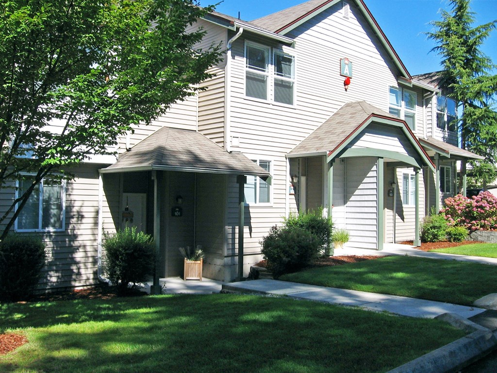 A house with a grey siding and a brown roof.