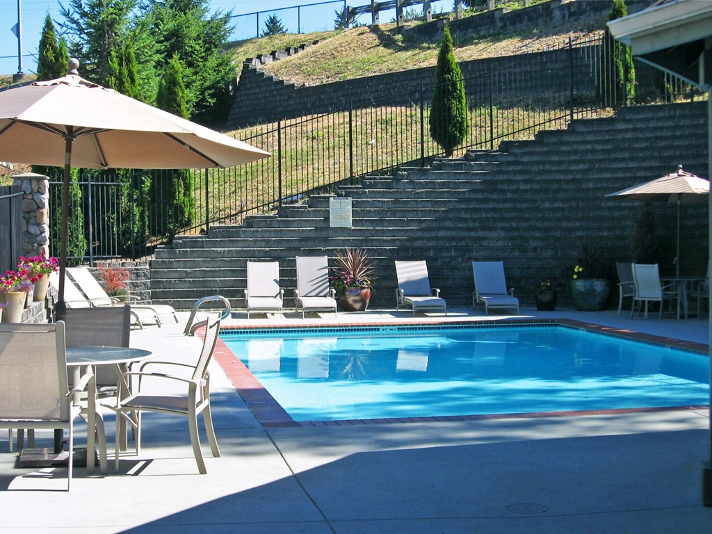 A pool with a table and chairs around it.