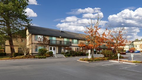A large building with a parking lot in front.