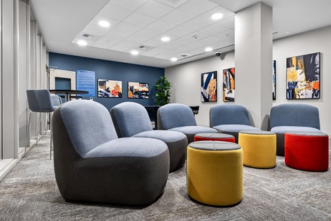 A modern waiting area with grey and yellow chairs and ottomans.