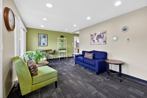 A living room with a green chair and a blue couch.