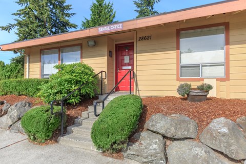 A building with a red door and a sign that says "Rental Office" on the top.