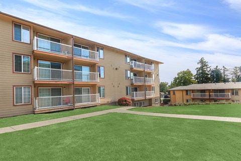 A large grassy area in front of apartment buildings.