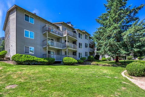 A large apartment building with a green lawn in front.