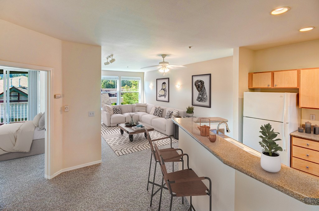 A well-lit, modern kitchen and living room with a dining area.