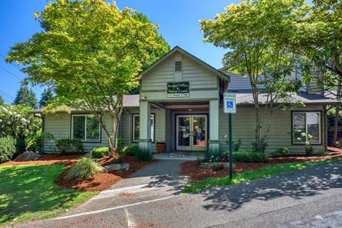 A building with a green lawn in front.