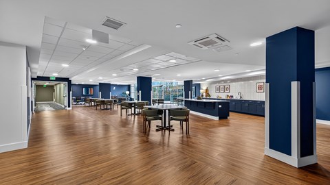 A large open space with wooden floors and a long table with chairs.