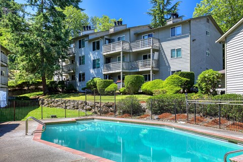 A swimming pool in front of a residential building.