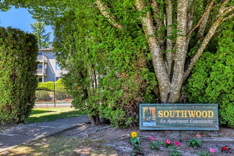 A sign for Southwood Apartment Community is surrounded by greenery.