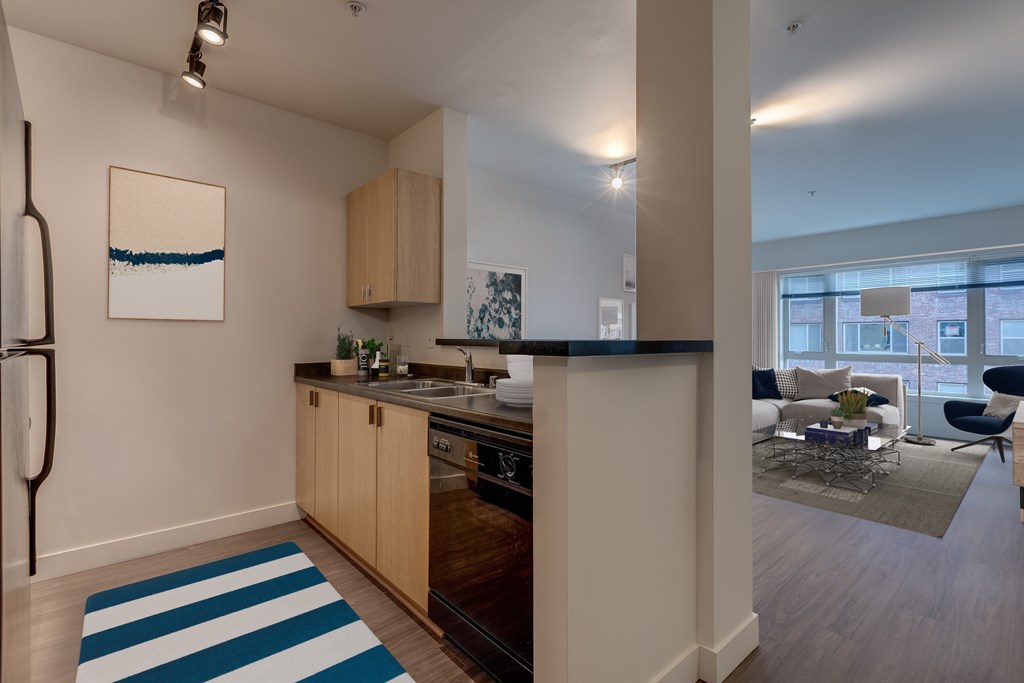 A kitchen with a blue and white striped rug on the floor.