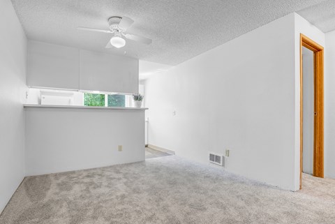 A room with a ceiling fan and a door.