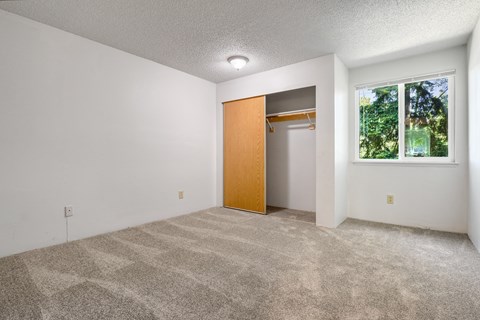 A room with a carpeted floor and a door leading to another room.