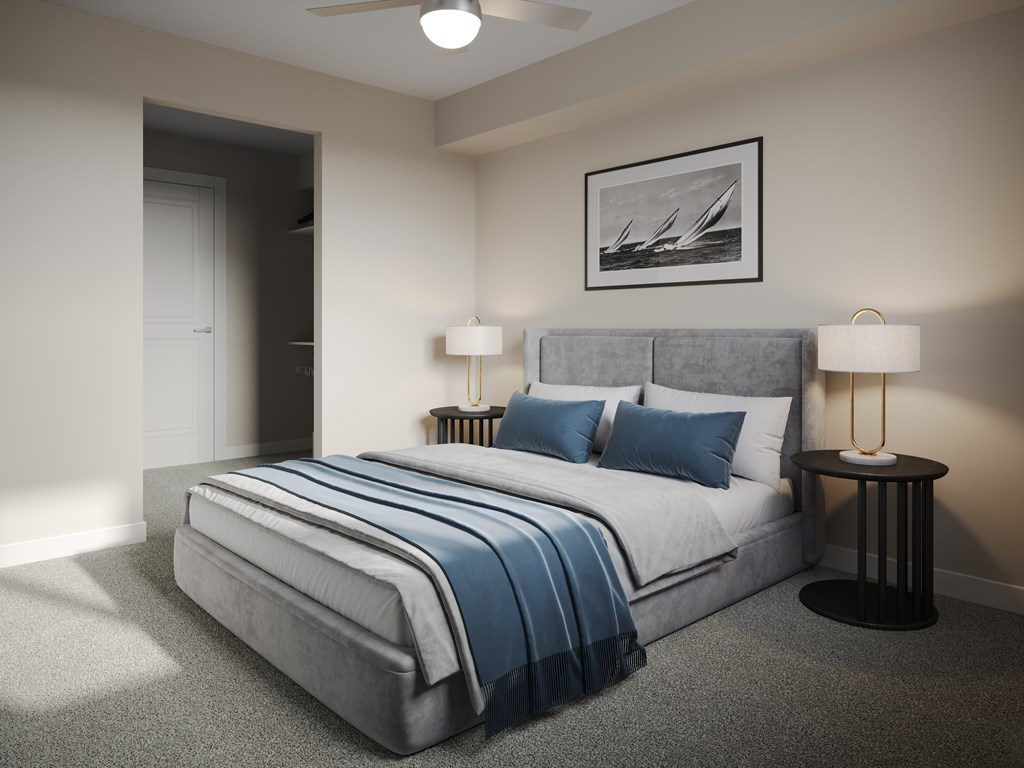 A bedroom with a bed, two lamps, and a picture on the wall.