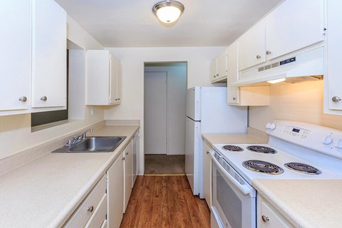 A kitchen with white appliances and cabinets.