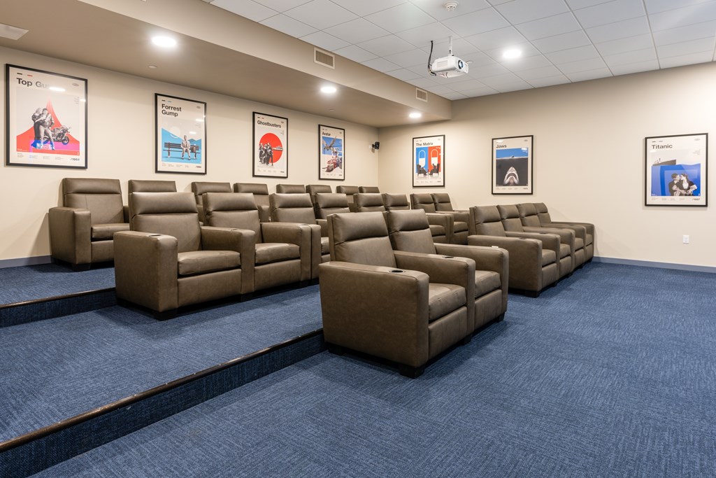 A room with a carpeted floor and a wall of chairs.