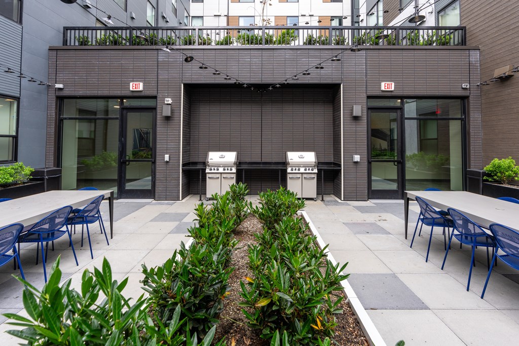 A modern building with a grey facade and a garden in front.