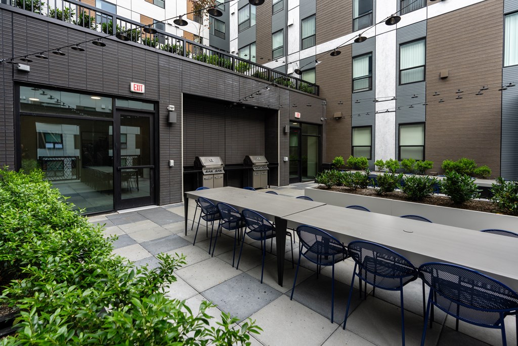 A patio with a table and chairs is surrounded by buildings.